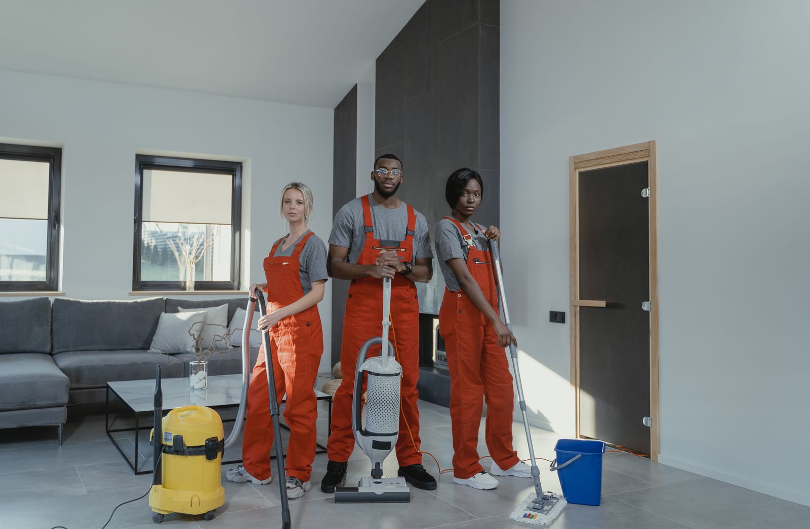 Professional cleaning crew with vacuums and mops ready to clean an office space