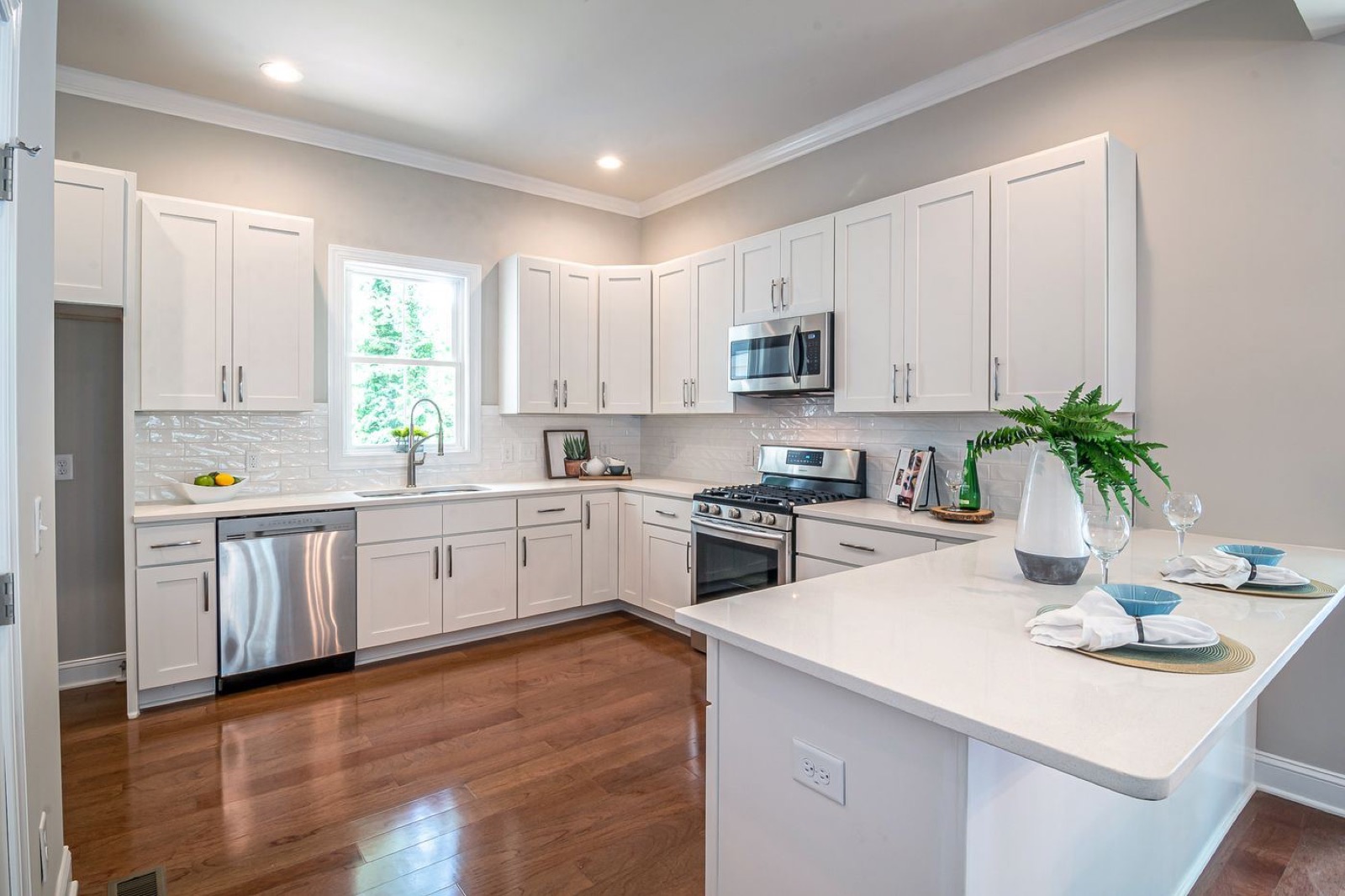 Spotless white kitchen with clean countertops and stainless appliances